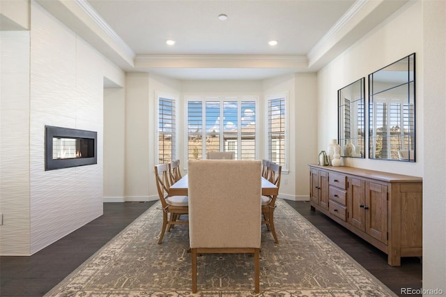 dining room featuring a tray ceiling, ornamental molding, and dark hardwood / wood-style flooring