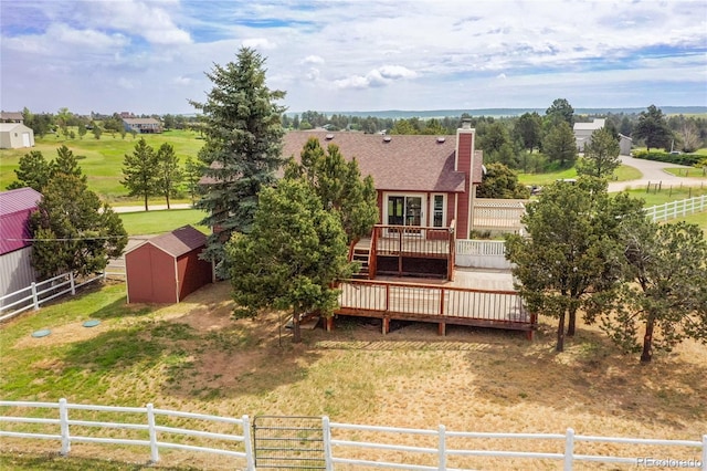 35675 Cheyenne Trl, Elizabeth, CO 80107 - back of house featuring a wooden deck, a chimney, a storage unit, and a shingled roof