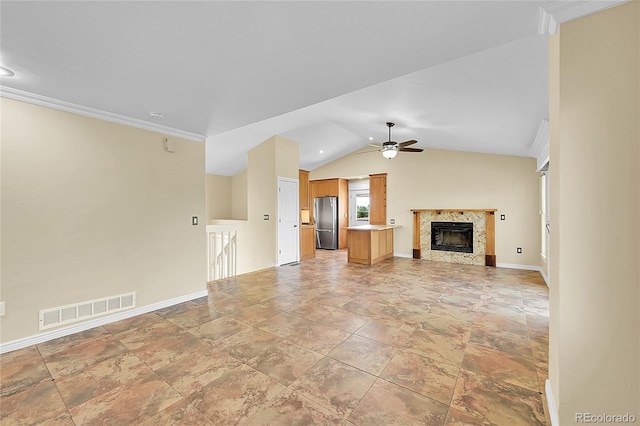 35675 Cheyenne Trl, Elizabeth, CO 80107 - unfurnished living room with light stone finish flooring, ceiling fan, a fireplace, vaulted ceiling, and crown molding
