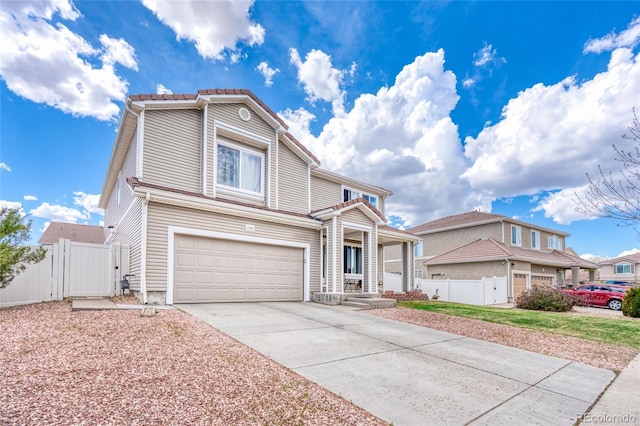 view of front of home with an attached garage, fence, driveway, and a gate