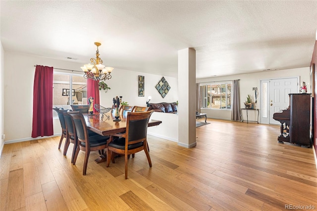 dining room featuring a chandelier, light wood-style flooring, and baseboards