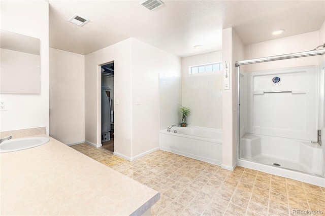 full bathroom with a stall shower, a garden tub, baseboards, and vanity
