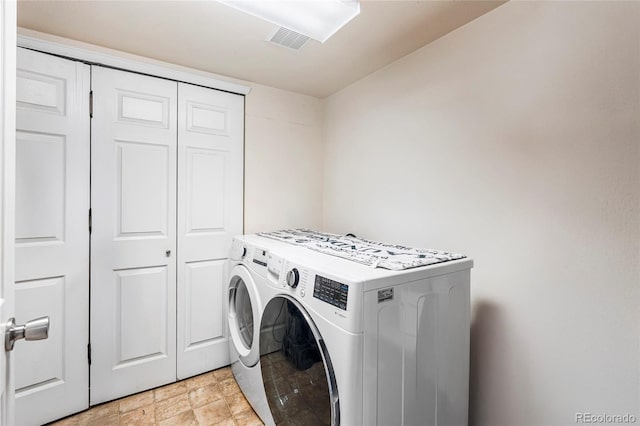 laundry room with washer and clothes dryer and stone finish flooring