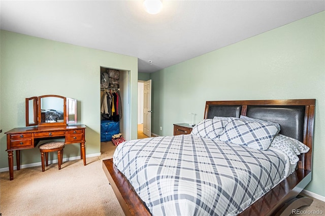 carpeted bedroom featuring baseboards, a closet, and a walk in closet