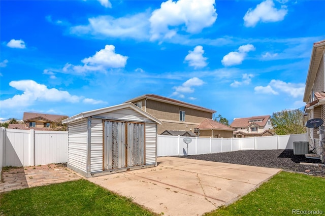garage with a storage unit, fence, and cooling unit