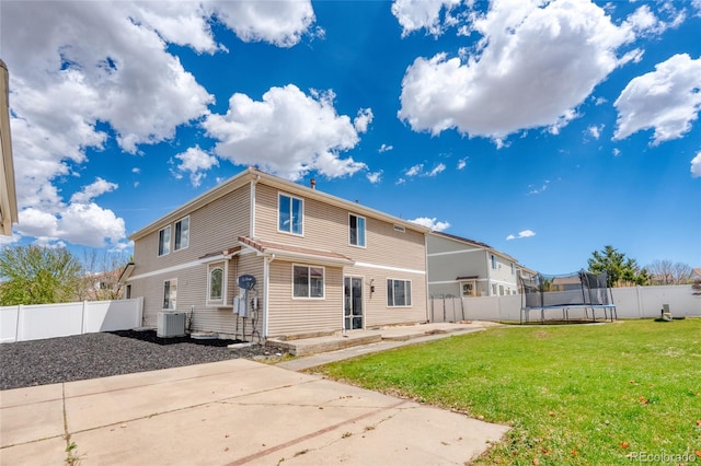 back of property featuring a trampoline, central AC unit, and a patio