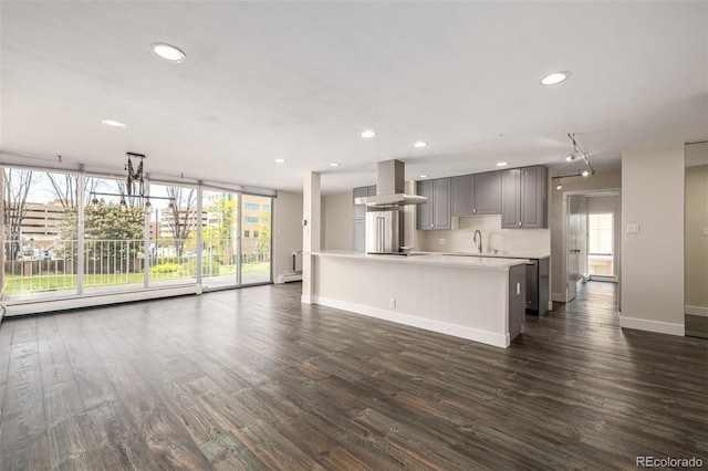 unfurnished living room with a sink, baseboards, recessed lighting, dark wood-style flooring, and baseboard heating