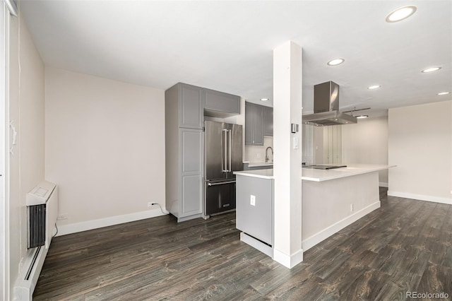 kitchen with high end refrigerator, gray cabinetry, island range hood, recessed lighting, and light countertops