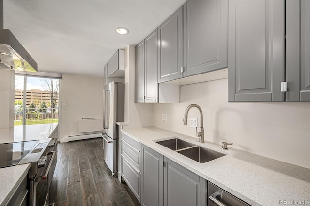 kitchen featuring a sink, gray cabinetry, appliances with stainless steel finishes, a baseboard radiator, and recessed lighting