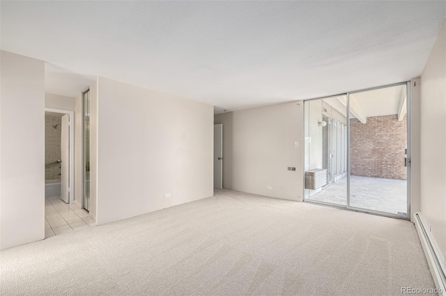 empty room featuring a baseboard heating unit and carpet