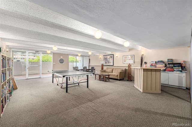 recreation room with carpet floors and a textured ceiling