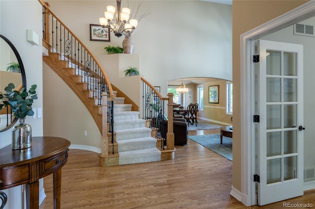 10859 Irving Ct, Westminster, CO 80031 - foyer entrance with a chandelier, arched walkways, light wood finished floors, stairway, and a high ceiling