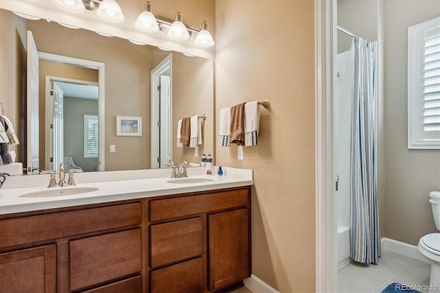 bathroom with tile patterned flooring, vanity, and toilet