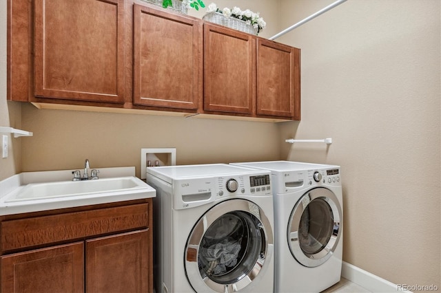 clothes washing area featuring cabinet space, a sink, baseboards, and separate washer and dryer