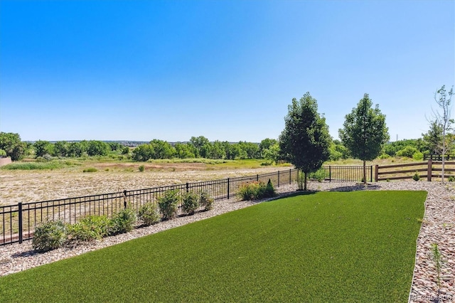 view of yard featuring fence and a rural view