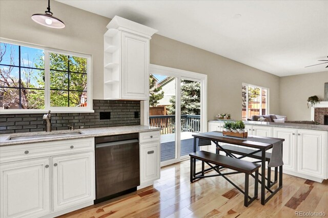 kitchen featuring dishwasher, a sink, light wood-type flooring, and open shelves