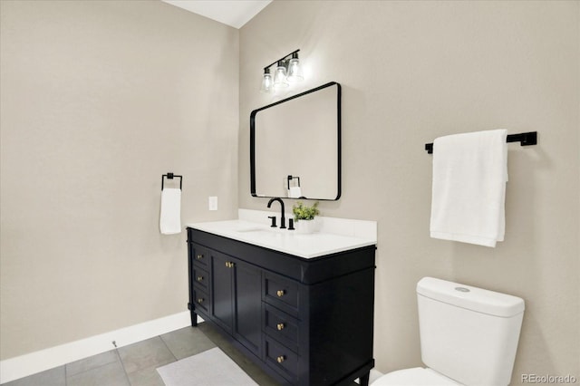 bathroom with toilet, baseboards, vanity, and tile patterned flooring