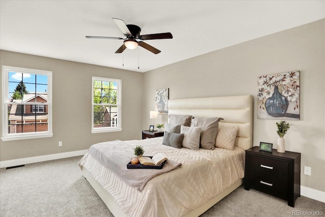 bedroom featuring baseboards, light carpet, and a ceiling fan