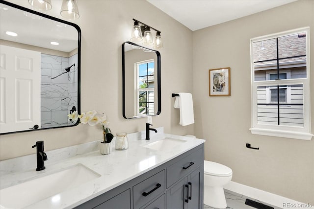 bathroom featuring marble finish flooring, baseboards, a shower, toilet, and double vanity