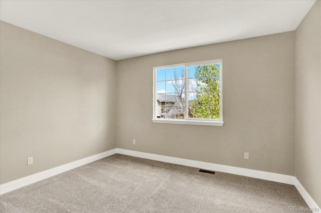 carpeted empty room featuring baseboards