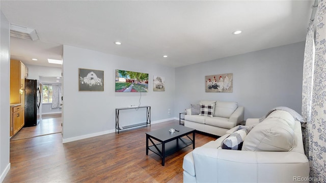 living room with recessed lighting, dark wood-style flooring, visible vents, and baseboards