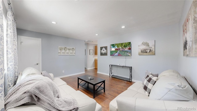 living area with baseboards, wood finished floors, and recessed lighting