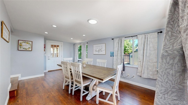 dining area featuring dark wood-style floors, a healthy amount of sunlight, and baseboards