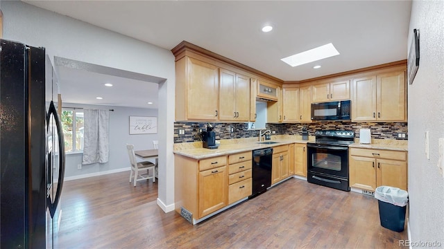 kitchen with dark wood-style floors, black appliances, and light brown cabinetry