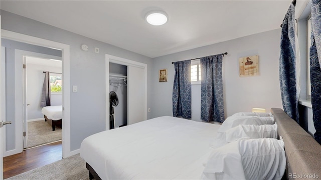 bedroom featuring baseboards, a closet, and wood finished floors