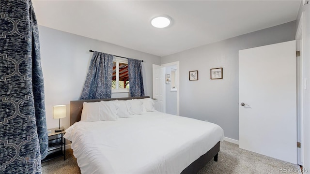 bedroom featuring carpet and baseboards