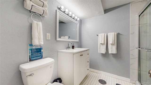 bathroom with a shower with door, a textured wall, toilet, vanity, and baseboards