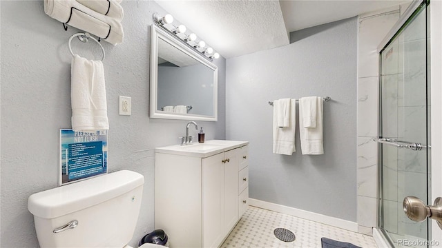 full bath featuring a shower with door, toilet, vanity, and baseboards