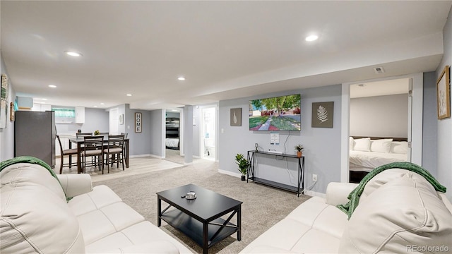 living room featuring recessed lighting, visible vents, baseboards, and light colored carpet