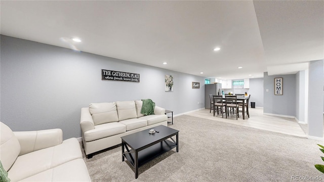 living room featuring light carpet, baseboards, and recessed lighting