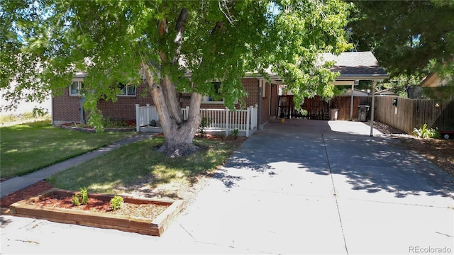 view of front of property with brick siding, fence, driveway, and a front lawn