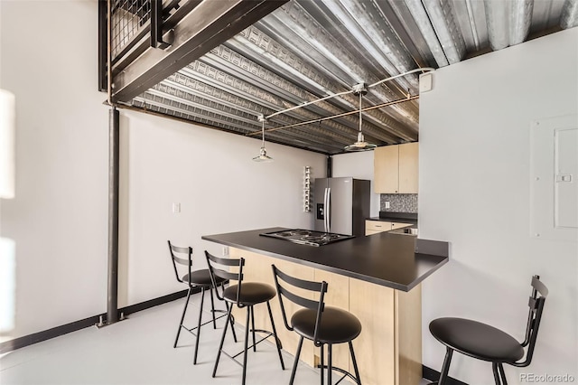 kitchen featuring a breakfast bar, backsplash, and appliances with stainless steel finishes