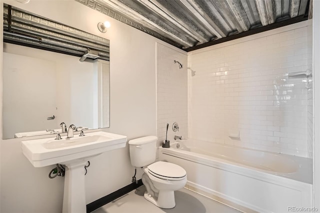 bathroom with toilet and tiled shower / bath