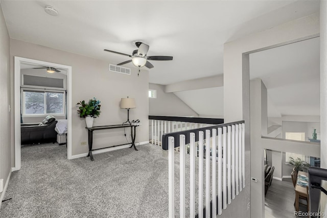 hallway featuring carpet flooring and vaulted ceiling