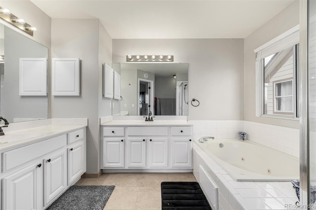 bathroom with vanity, tile patterned floors, and a relaxing tiled tub