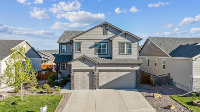 6616 Amur Ln, Castle Rock, CO 80108 - craftsman house featuring concrete driveway, an attached garage, a shingled roof, and stone siding