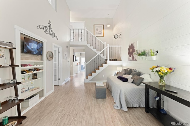 interior space with light hardwood / wood-style floors and a towering ceiling