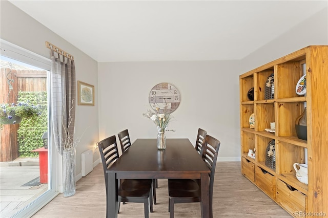 dining area with light hardwood / wood-style floors and a healthy amount of sunlight