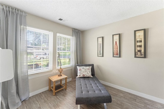 living area featuring a textured ceiling and light hardwood / wood-style flooring