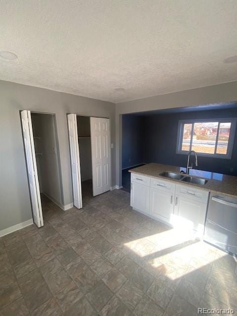 kitchen featuring white cabinetry, sink, a textured ceiling, and dishwasher