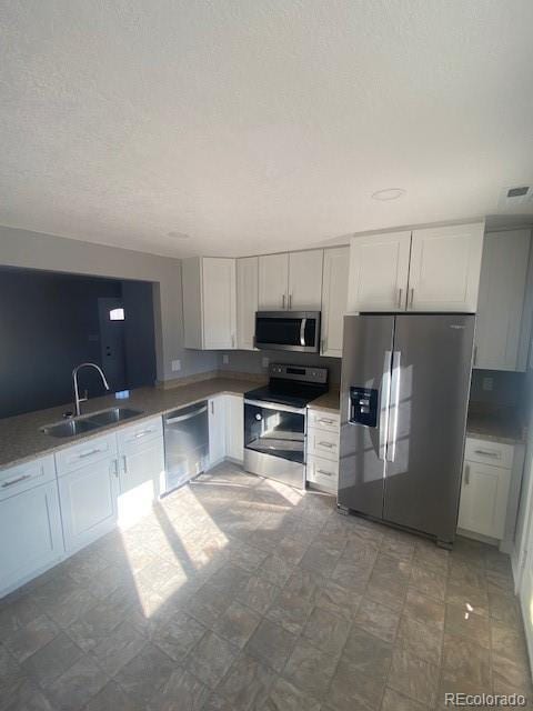 kitchen with appliances with stainless steel finishes, sink, and white cabinets