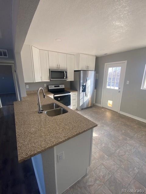 kitchen featuring stainless steel appliances, sink, white cabinets, and kitchen peninsula