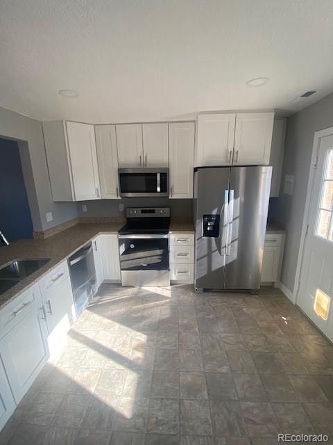 kitchen featuring stainless steel appliances, sink, and white cabinets