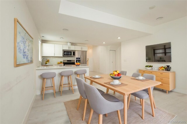 dining room with light hardwood / wood-style flooring and sink