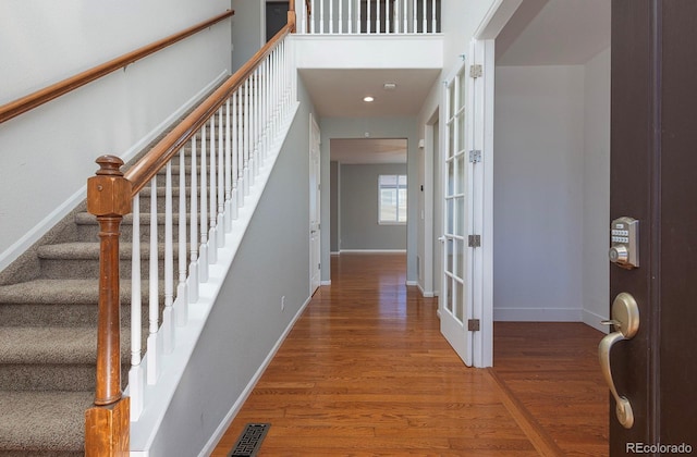 foyer entrance with hardwood / wood-style flooring and french doors