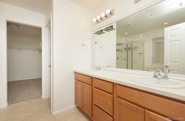 bathroom with tile patterned flooring, vanity, and a shower with shower door